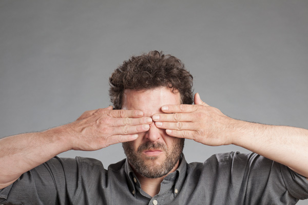 image of a man covering eyes ignoring auto glass damage
