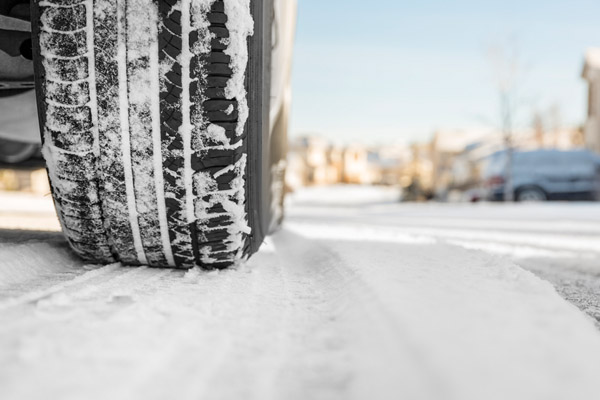 car tire in snow depicting driving in winter weather