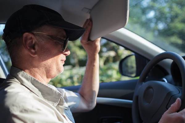 image of a man driving with a sun glare due to the fall equinox