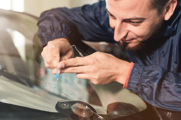 image of an autoglass technician repairing a windshield chip