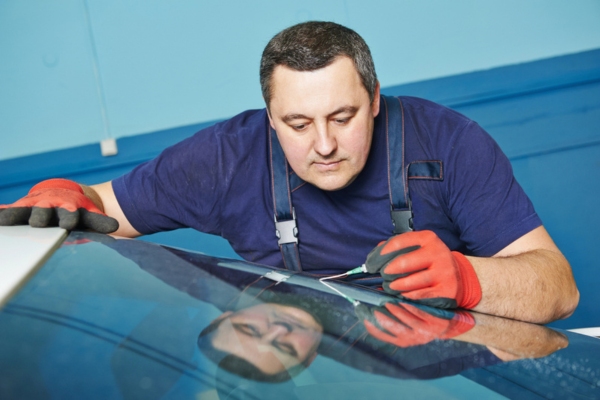 worker fixing windshield chip