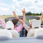 image of a couple driving in the summer