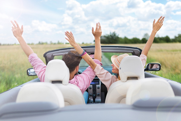 image of a couple driving in the summer