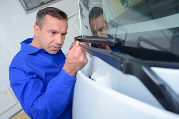 man performing windshield wiper inspection