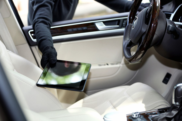 Man burglar steals the tablet of car from broken side window