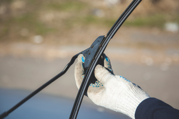 image of auto glass technician replacing windshield wipers