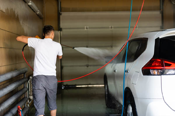 image of a person spraying car checking for windshield leak after replacement