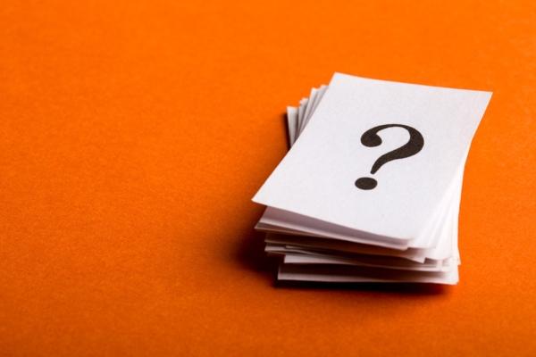 question mark on a stack of paper depicting FAQs about Windshield Chip Replacement