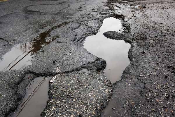 image of a pot hole in street depicting windshield replacement prevention