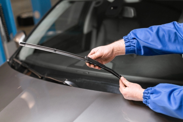 auto glass technician replacing windshield wipers