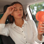 image of a woman suffering from heat in car depicting how to keep car cool in the summer