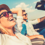 image of a couple driving in convertible car depicting convertible auto glass issues