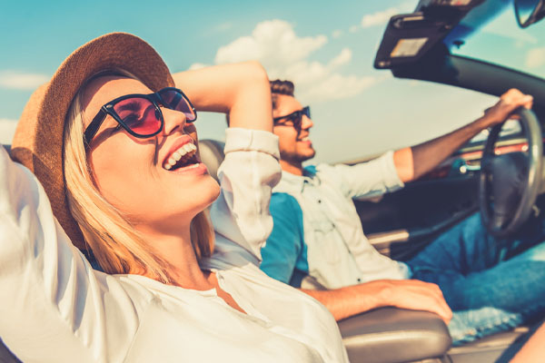 image of a couple driving in convertible car depicting convertible auto glass issues