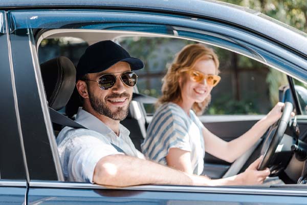 happy couple in car depicting auto glass accessories