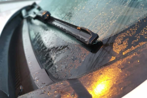 photo of car windshield with raindrops and wiper blade