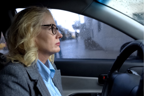 serious looking woman driving under the rain