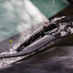 Small hail ice balls caught on black car's windshield wipers