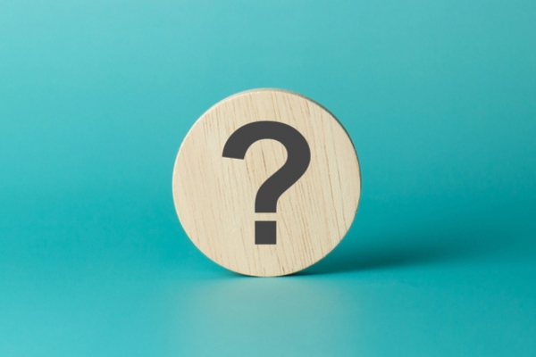question mark printed on a circular wooden chip depicting FAQS about leaky windshield repair